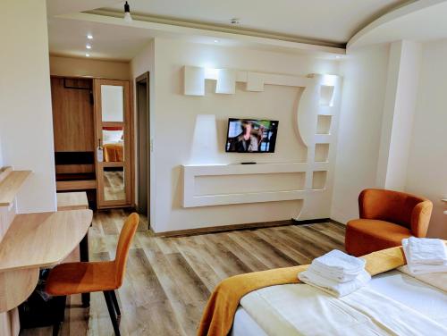 una stanza con un letto e una TV su una parete di Hotel Tausendschön a Südbrookmerland