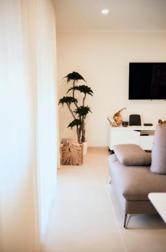 a living room with a couch and a tv at Balili Home by the Sea in Ferrel