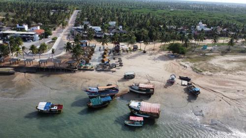 a group of boats in the water near a beach at Pousada Bate Vento in Itarema