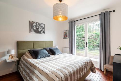 カップブルトンにあるVilla Terrama Capbretonのベッドと大きな窓のある寝室