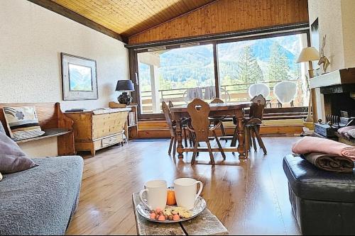 - un salon avec une table et une salle à manger avec vue dans l'établissement Charming T3 with terrace in Chamonix, à Chamonix-Mont-Blanc