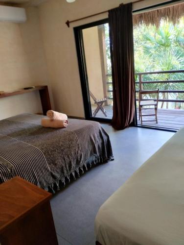 a bedroom with a bed with a towel on it at Hotel Uolis Nah in Tulum