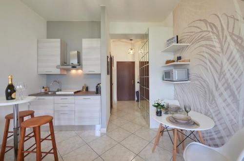 a kitchen with white cabinets and stools in a room at Stella Apartment on Lake Como in Onno