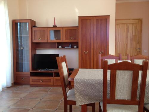 a dining room with a table and a television at VIDOR Vendégház in Demjén