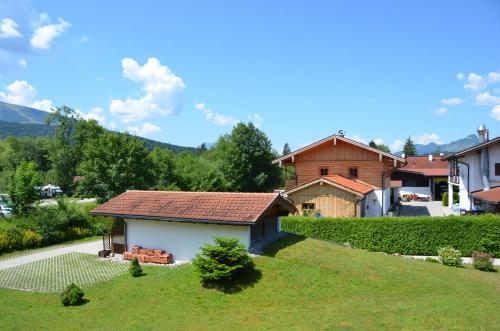 a small house with a roof on a grass field at Ferienwohnung Sonnenwinkl in Reit im Winkl