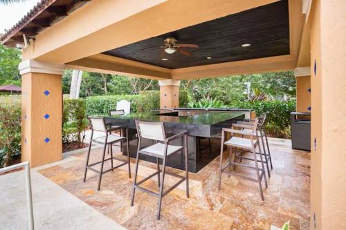 an outdoor kitchen with a black table and chairs at Urban Luxe Aventura 22 Retreat in Aventura