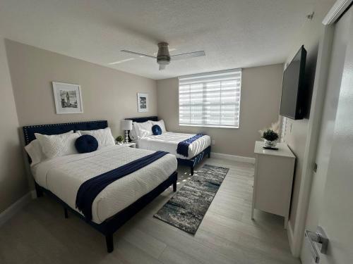 a bedroom with two beds and a flat screen tv at Urban Luxe Aventura 22 Retreat in Aventura