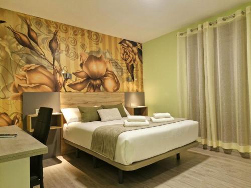 a bedroom with a bed with a painting on the wall at Feeling Home - Suites&Rooms in León