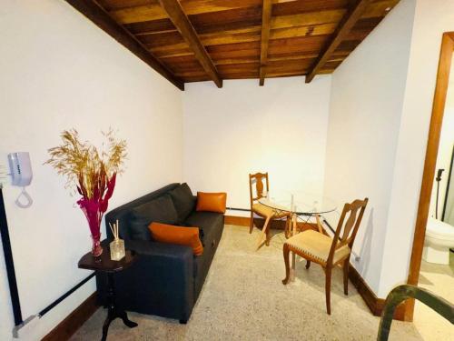 a living room with a couch and a table at Flat2 Charmoso ar condicionado próx ICHF-UFOP Mariana MG in Mariana