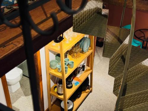 a shelf with dishes and other items on it at Flat2 Charmoso ar condicionado próx ICHF-UFOP Mariana MG in Mariana