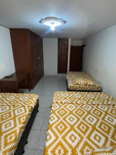 a room with two beds and a table in it at Hostal Jireth in Floridablanca