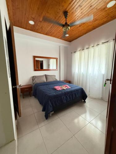 a bedroom with a bed and a ceiling fan at hostal orquideas de auri in Necoclí