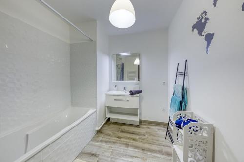 ein weißes Badezimmer mit Badewanne und Waschbecken in der Unterkunft En famille et à table, parking gratuit in Noisy-le-Sec