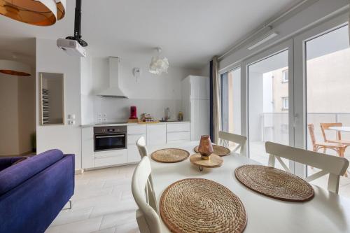 une cuisine et une salle à manger avec une table et des chaises dans l'établissement En famille et à table, parking gratuit, à Noisy-le-Sec