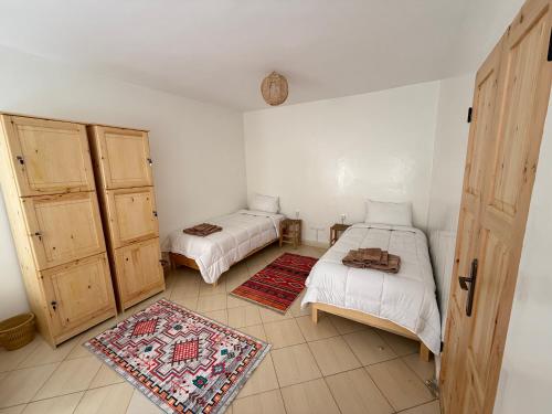 a room with two beds and two cabinets in it at Orange Surf House in Agadir