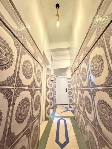 a hallway with tiled walls and a white door at Orange Surf House in Agadir