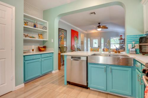 a kitchen with blue cabinets and a stainless steel sink at Boho-Chic Retreat with Yard, 22 Mi to Dtwn Austin! in Kyle
