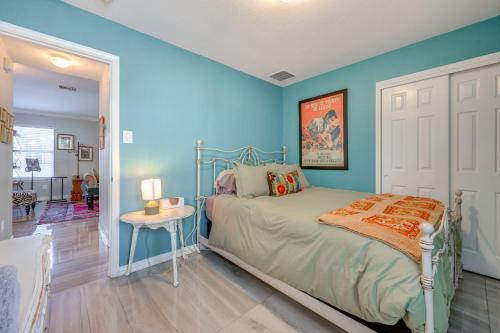 a bedroom with blue walls and a bed and a table at Boho-Chic Retreat with Yard, 22 Mi to Dtwn Austin! in Kyle