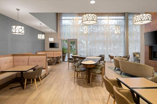 a restaurant with tables and chairs and windows at Homewood Suites by Hilton Anaheim Conv Ctr/Disneyland Main in Anaheim