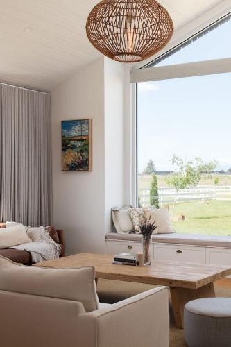 a living room with a table and a large window at A Farmhouse escape 15 minutes from Launceston in Carrick