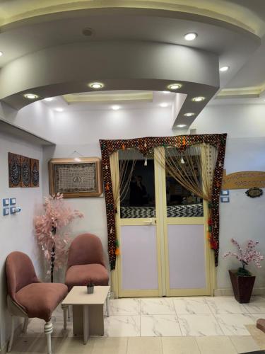 a waiting room with two chairs and a door at Alwaha safari hotel in Qasr Al Farafirah