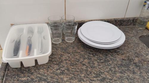 a bathroom with a toilet and glasses on a counter at Apartamento Brisa 202 in Pedra de Guaratiba