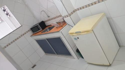 a small kitchen with a sink and a refrigerator at Apartamento Brisa 202 in Pedra de Guaratiba