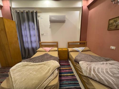 a room with three beds in a room at Alwaha safari hotel in Qasr Al Farafirah