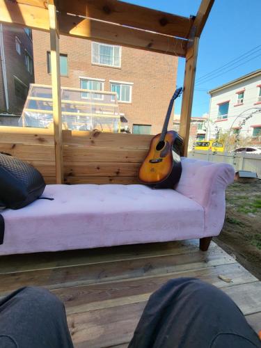 a guitar sitting on a bed in a gazebo at Wonju Aunt Home in Wonju