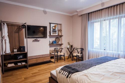 a bedroom with a bed and a tv and a table at Agata Hotel Boutique & Spa in Mexico City