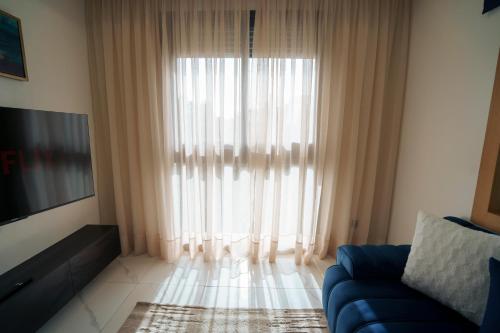 a living room with a blue couch and a large window at Emplacement Central Lumineux & Chic Prés de Station Tramway KFC Et Carrefour Abdelmoumen Et 2 Mars Casablanca in Casablanca