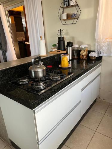 a kitchen counter with a stove with a pot on it at Casa amarela do porto in Imbituba