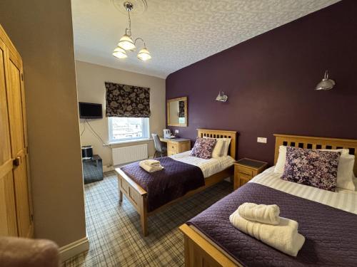 Una habitación de hotel con dos camas y una ventana. en Nama-Stay Harrogate, en Harrogate
