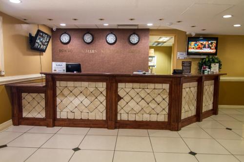 a lobby with a counter with clocks on the wall at La Copa Hotel in McAllen