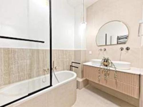 une salle de bain avec une baignoire, un lavabo et un miroir dans l'établissement New flat with AC Porte Maillot Arc de Triomphe, à Paris
