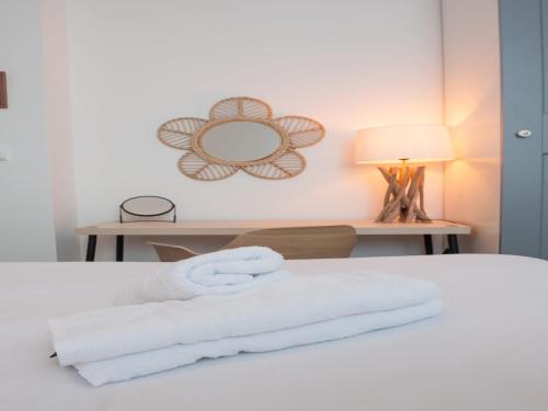 a bedroom with a bed with white towels on it at Modern Apartment by the Sea in Porspoder