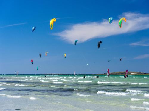 a group of people flying kites on the beach at Modern Apartment by the Sea in Porspoder