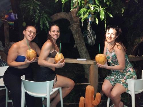 a group of three women sitting in chairs holding drinks at Tidododesiles in Bouillante