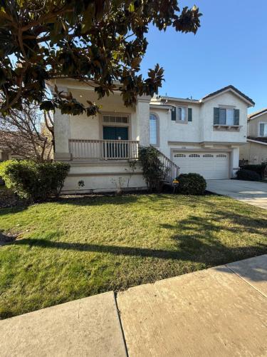 a large house with a yard with a driveway at Luxury Escape in Stockton
