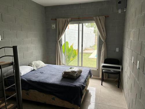 a bedroom with a bed and a large window at El quincho in Villa María