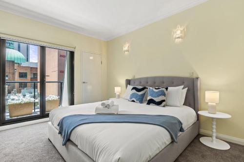 a bedroom with a large bed and a large window at Modern Comfort in the Heart of Sydney in Sydney
