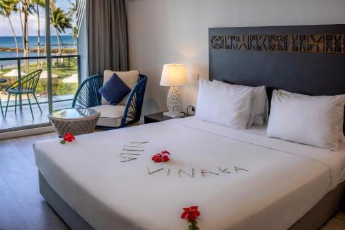 a bedroom with a bed with a view of the ocean at The Pearl South Pacific Resort, Spa & Golf Course in Pacific Harbour