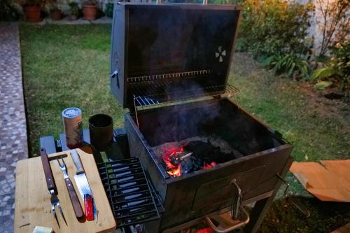 a barbecue grill with a fire in it at Hostal Boonen in Santiago