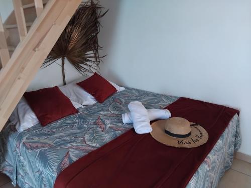 a bedroom with a bed with a hat on it at Tidododesiles in Bouillante