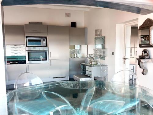 a kitchen with a glass table in the middle of it at Village House in France with Private Pool in Bagnols-en-Forêt