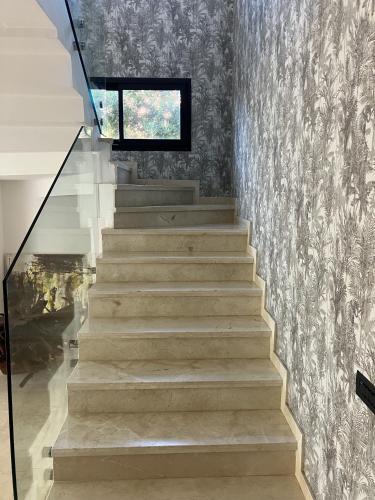 a staircase in a house with a wall at Seafront Luxury Villa with Amazing pool! in Dar Bouazza