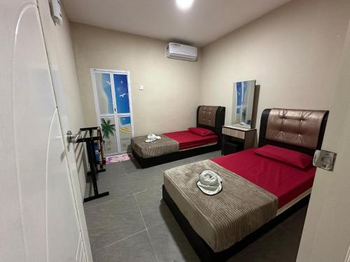 a room with two beds in a room at Chatek Family Inn in Kampong Pasir Hantu