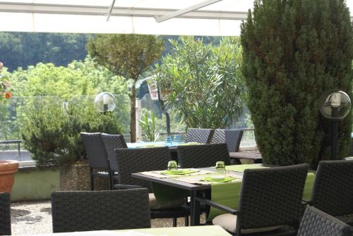 an outdoor patio with tables and chairs and trees at Hotel Storchen in Rheinfelden