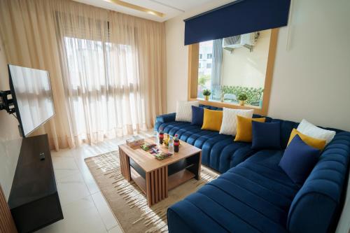 a living room with a blue couch and a table at Emplacement Central Lumineux & Chic Prés de Station Tramway KFC Et Carrefour Abdelmoumen Et 2 Mars Casablanca in Casablanca