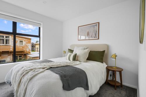 a bedroom with a bed and a large window at Stylish and Sleek City Stay in Christchurch